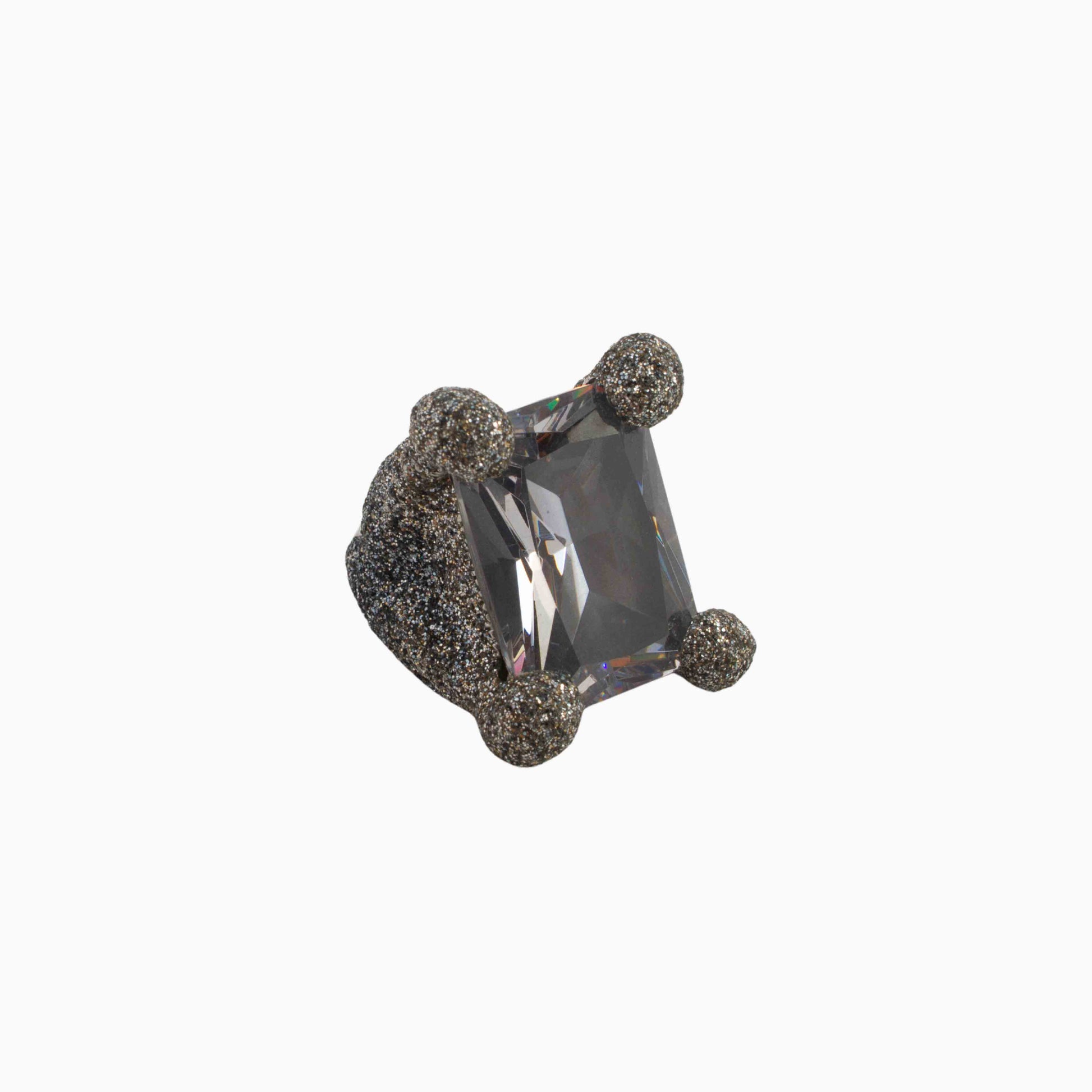 Ring with a large rectangular gemstone and smaller round stones on a white background