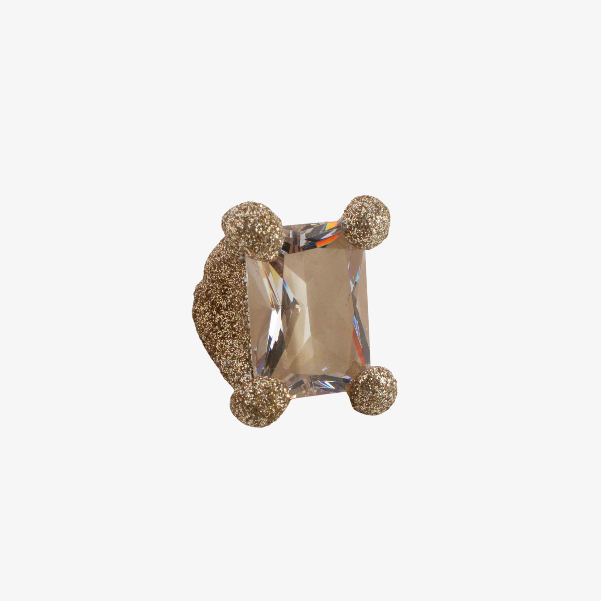 Gold ring with a central gemstone on a white background