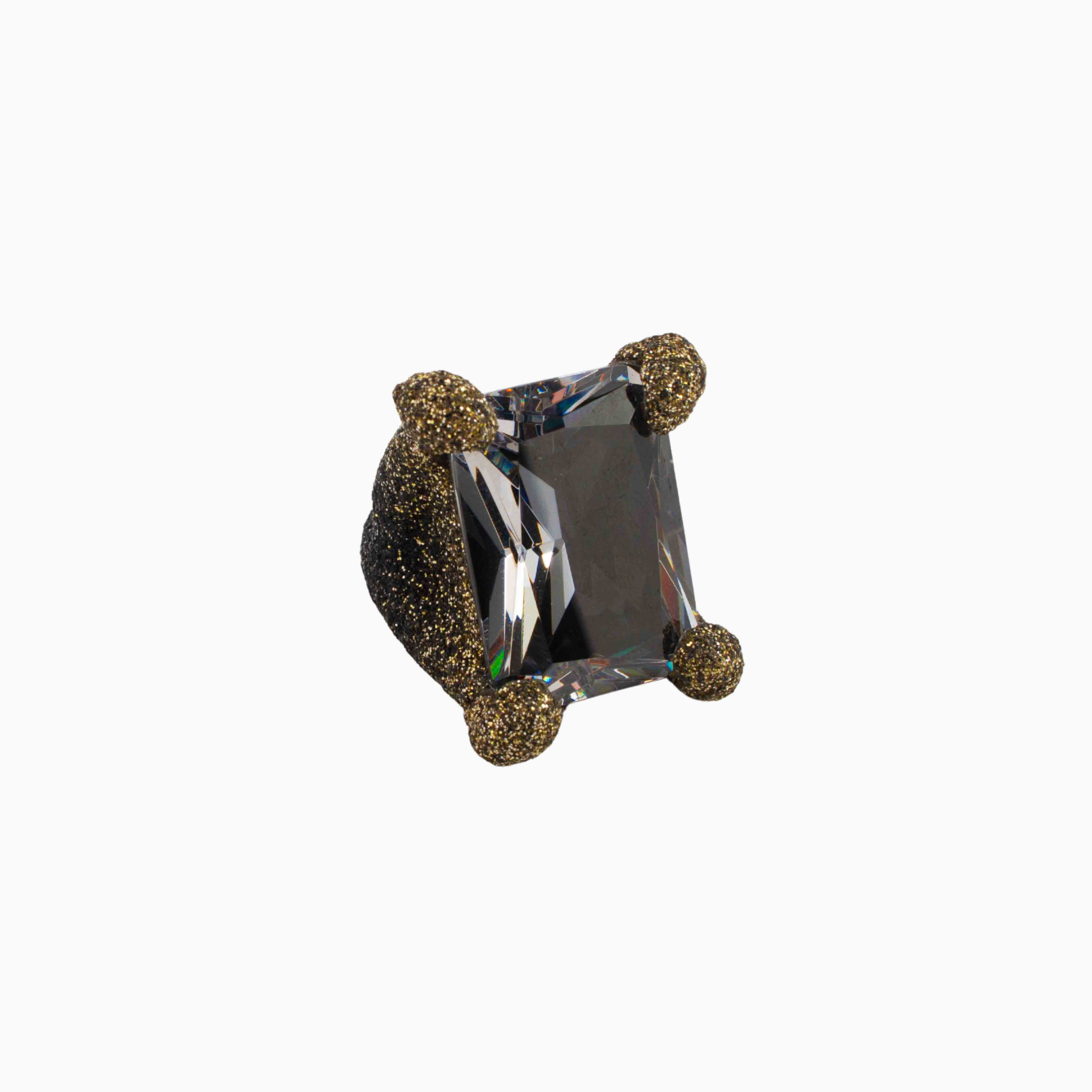 Crystal ring with gold accents on a white background