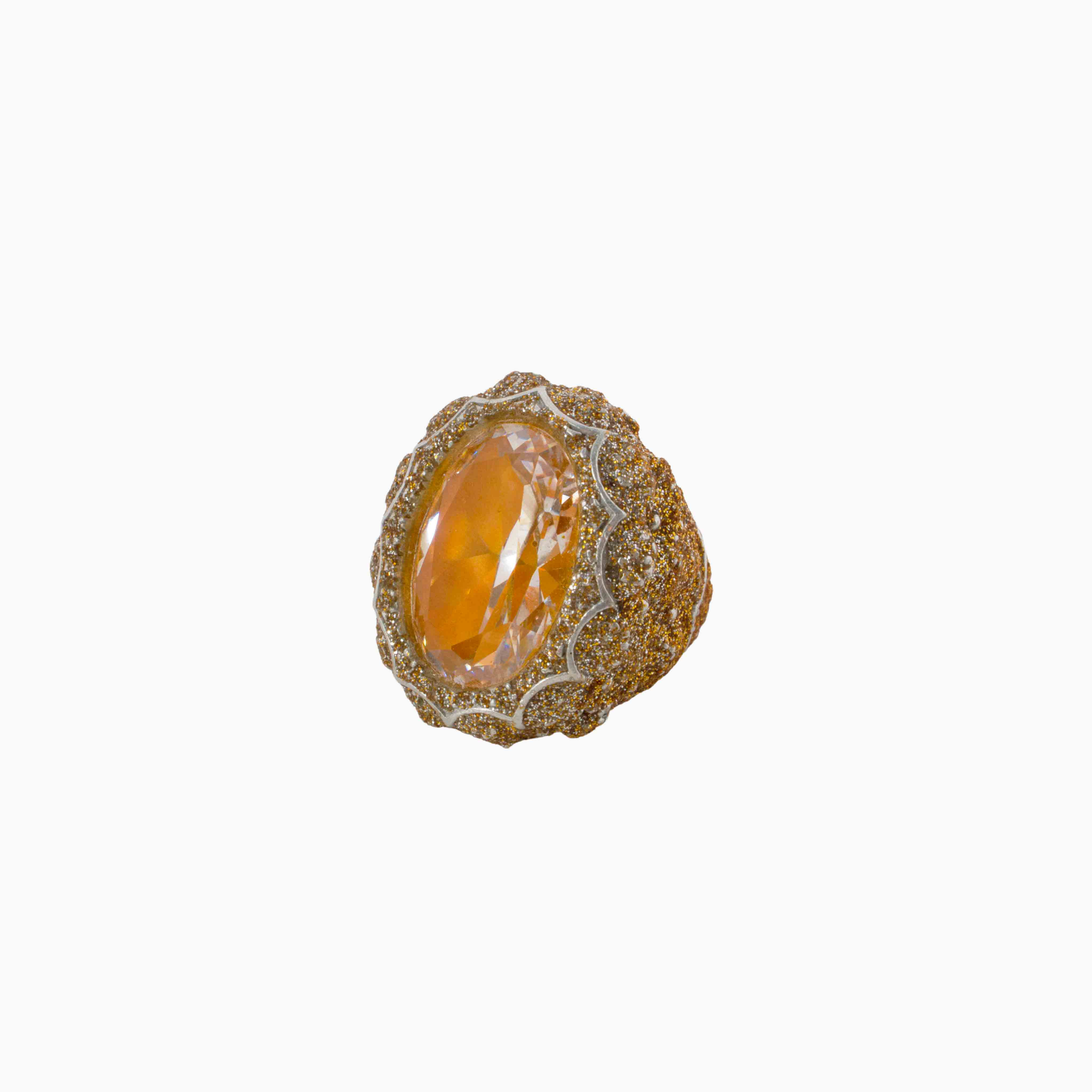 Gold ring with a large orange gemstone on a white background