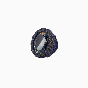 Black stone with a central clear gemstone on a white background