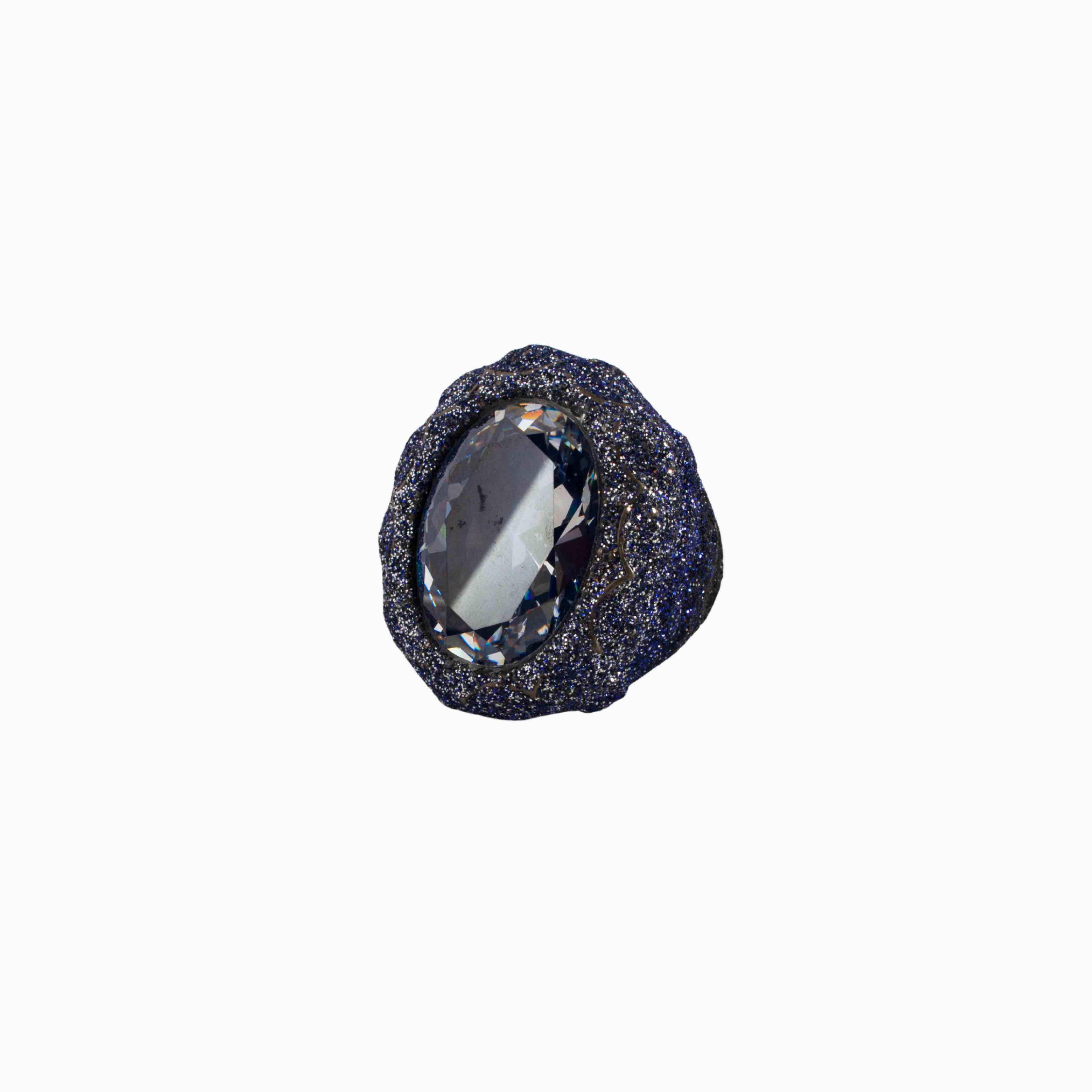 Black stone with a central clear gemstone on a white background