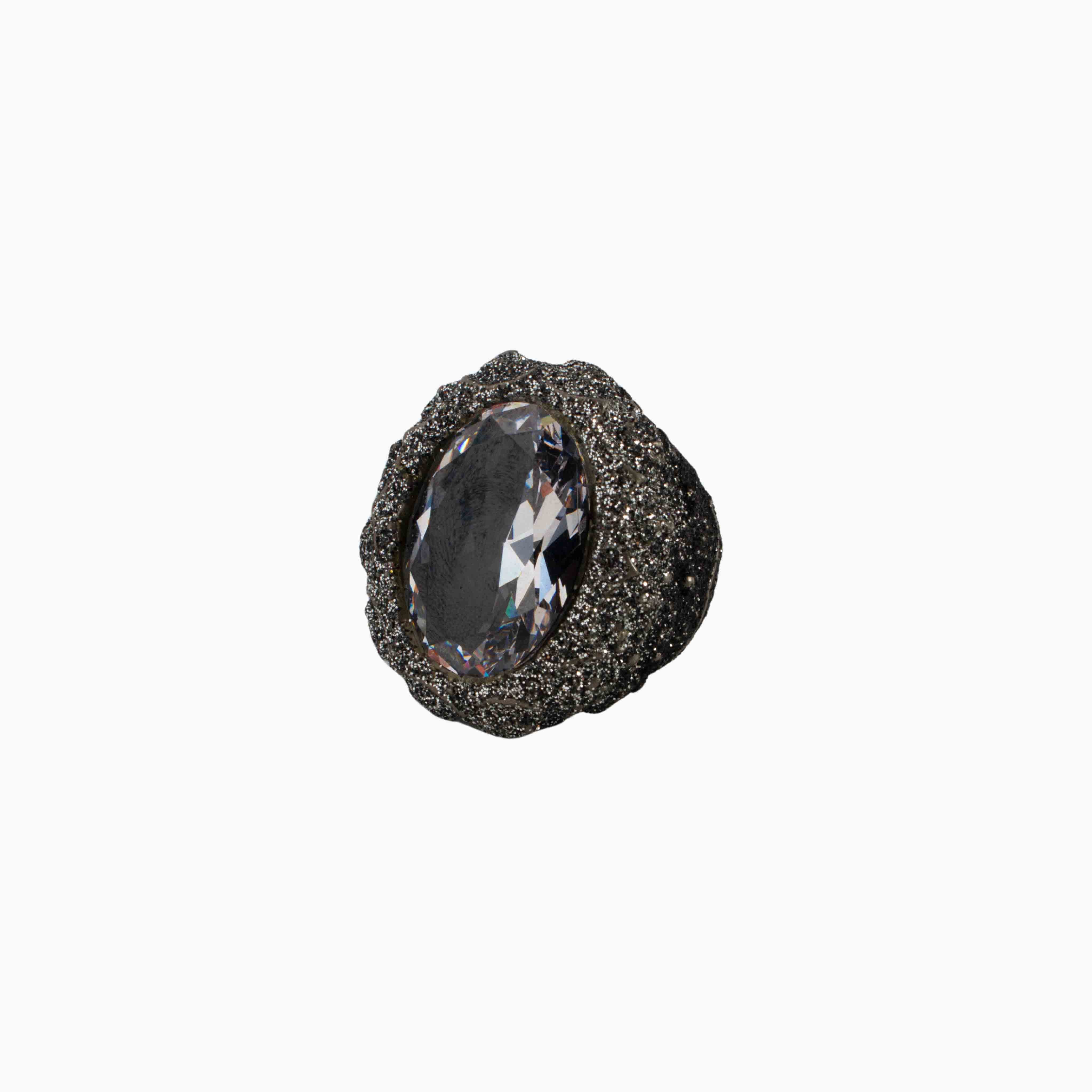 Decorative knob with a textured surface and central gemstone on a white background