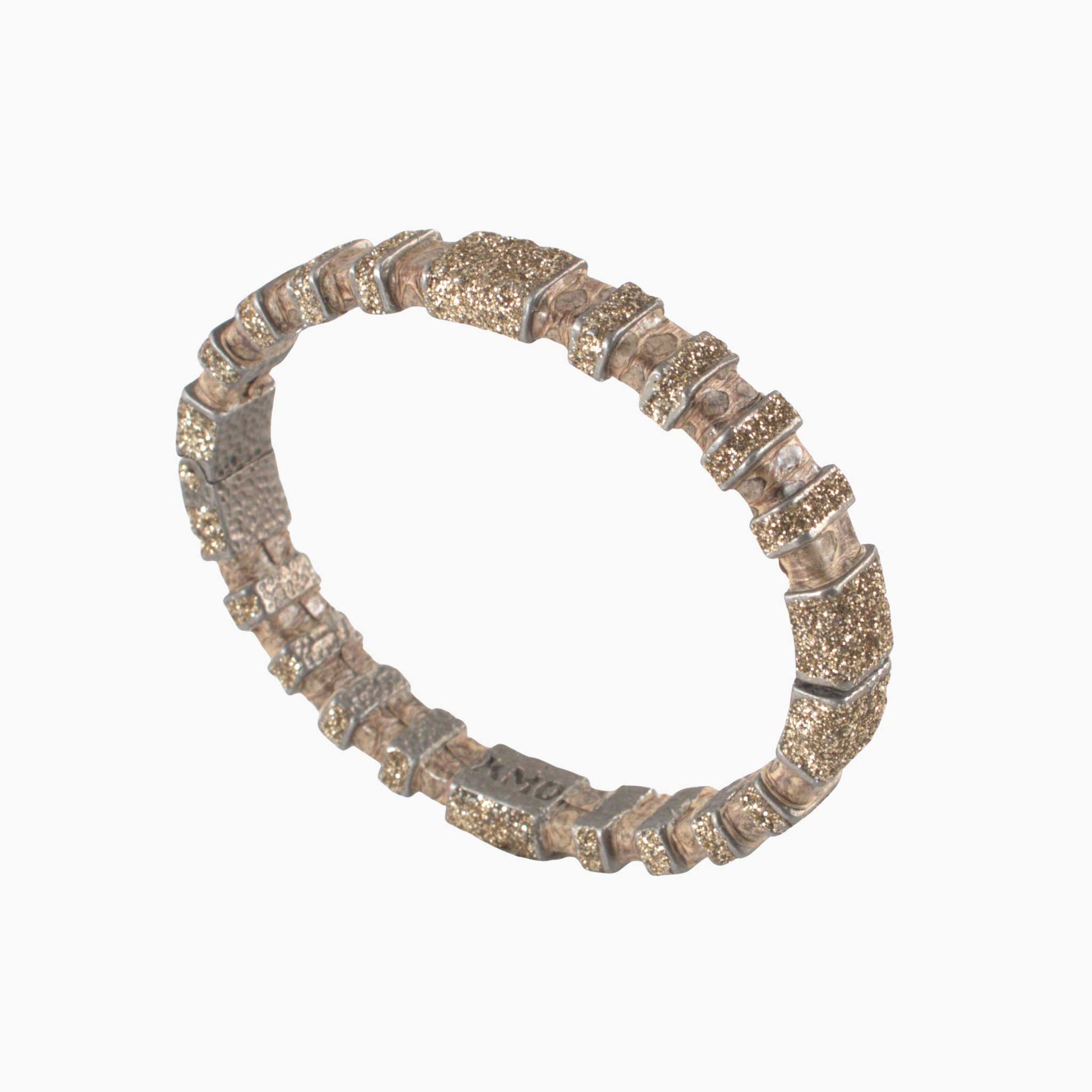 Silver bracelet with glittery stones on a white background