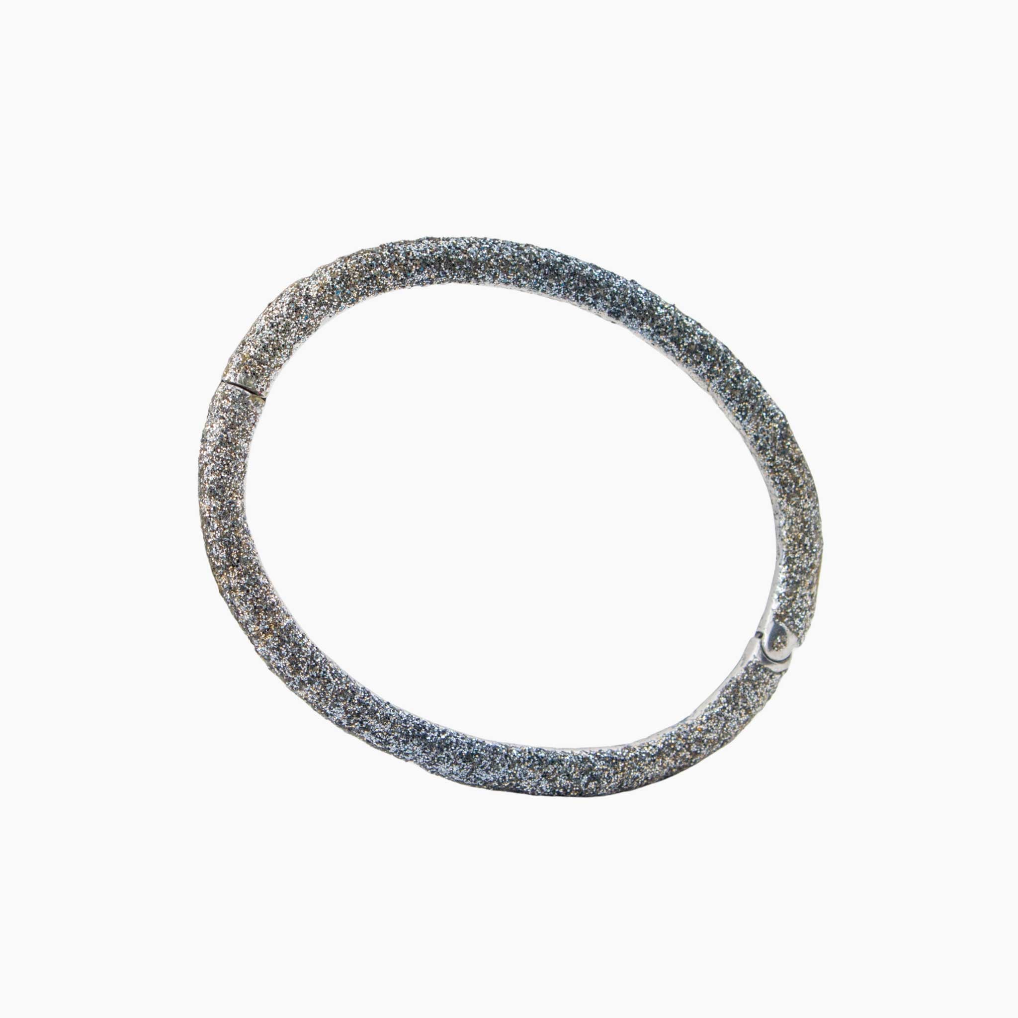 Silver bracelet with a textured band on a white background