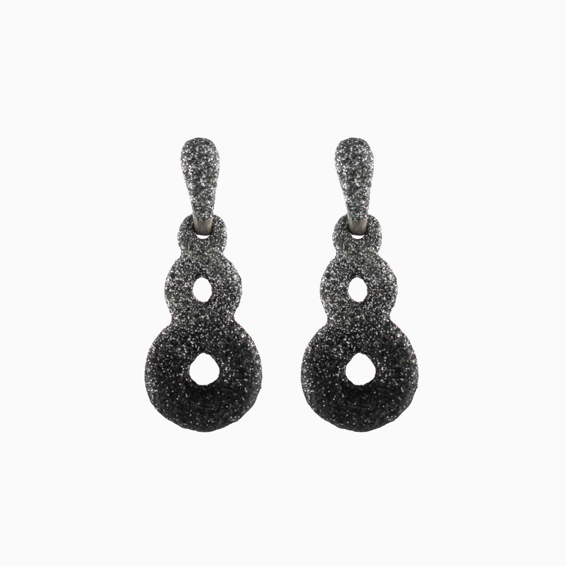 Pair of black textured earrings on a white background
