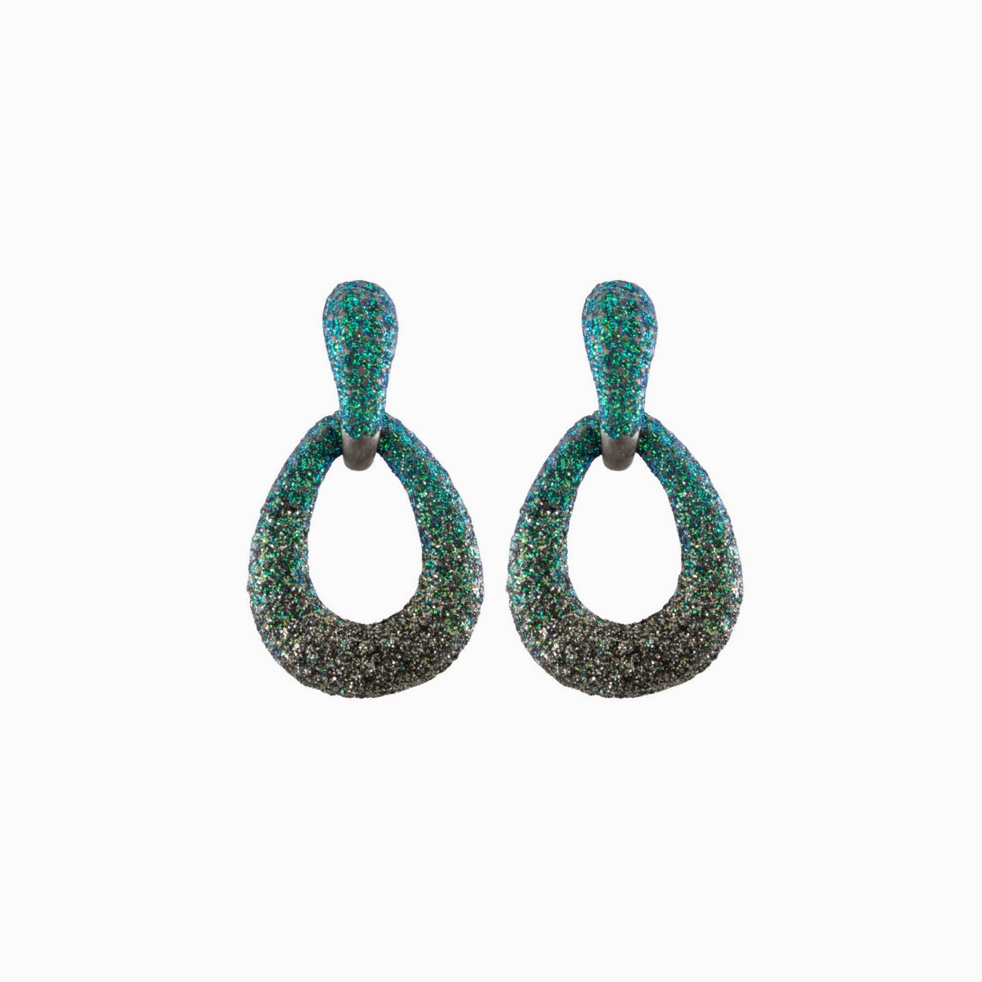 Pair of earrings with green and black glittery finish on a white background