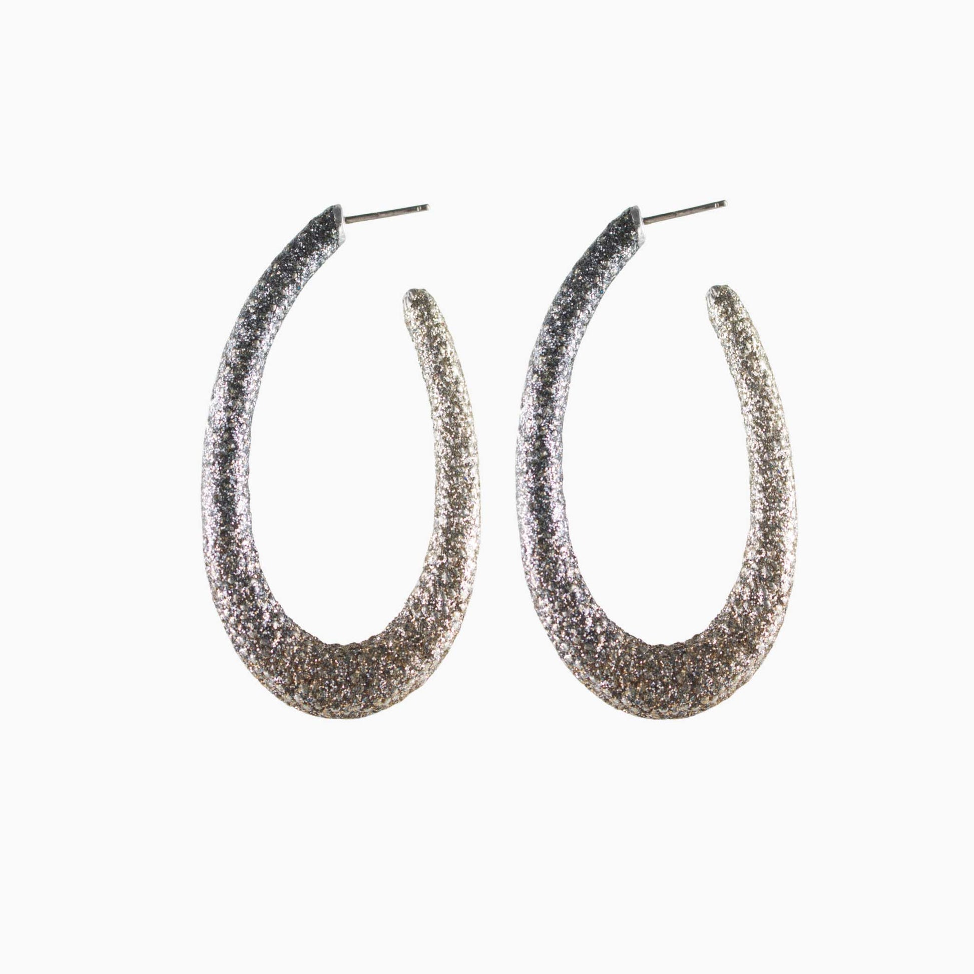 Pair of glittery hoop earrings on a white background