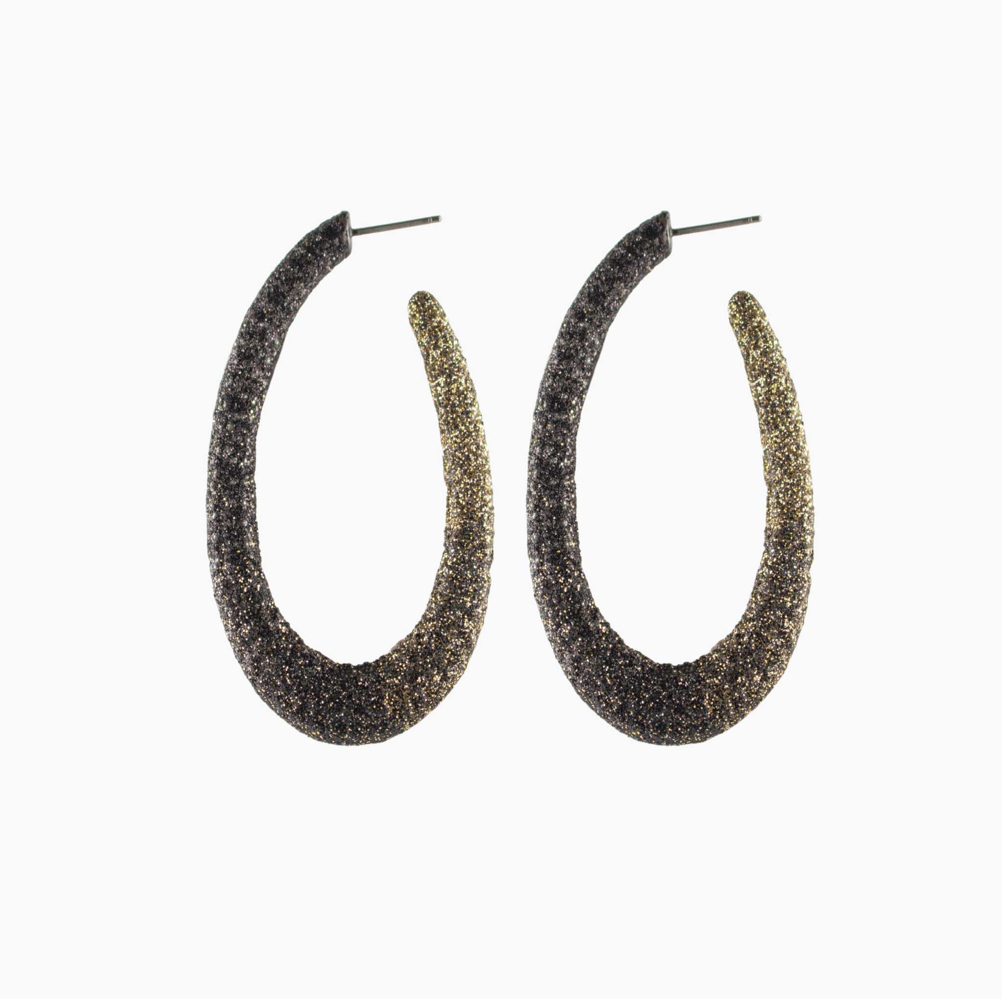 Pair of glittery hoop earrings on a white background