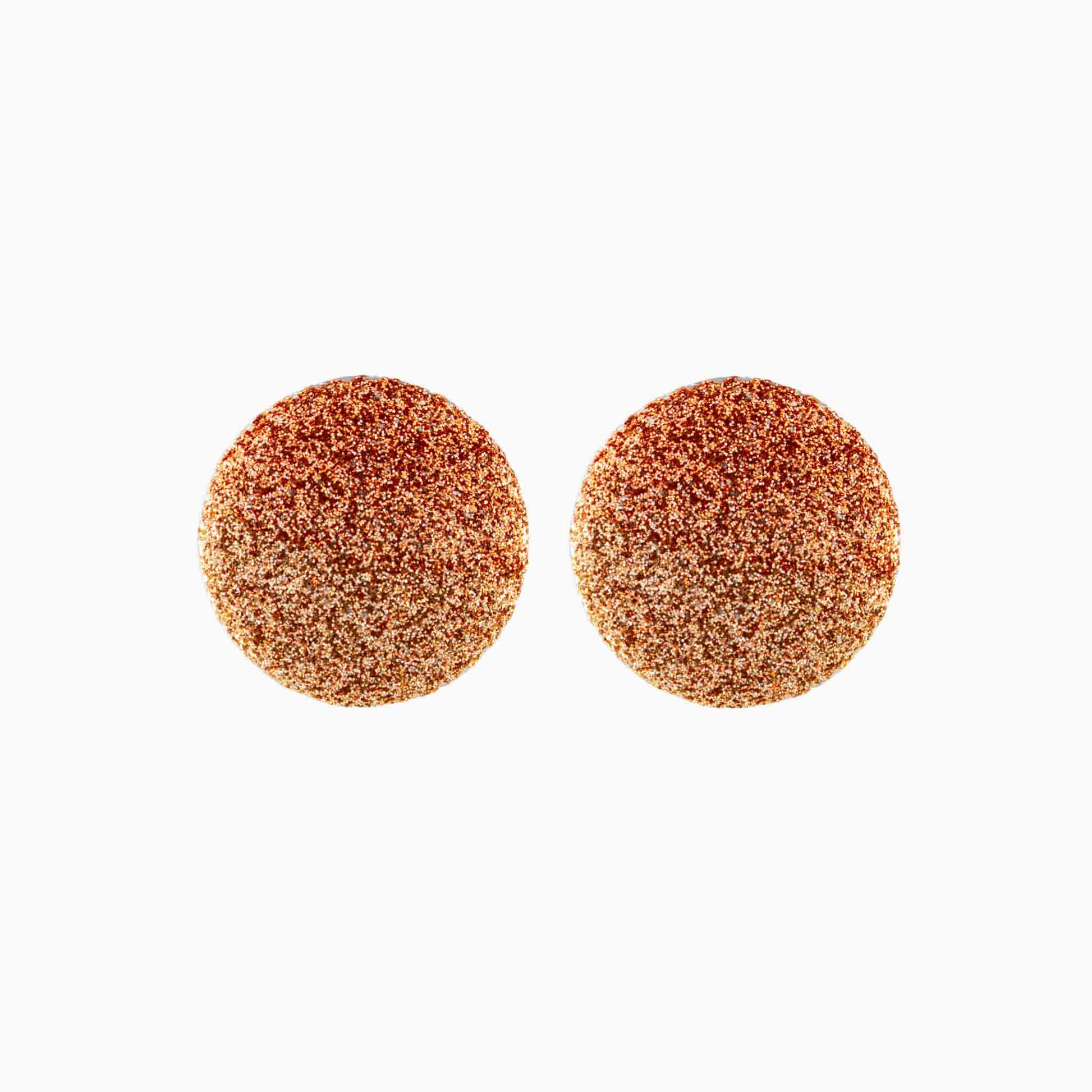 Pair of round, glittery earrings on a white background