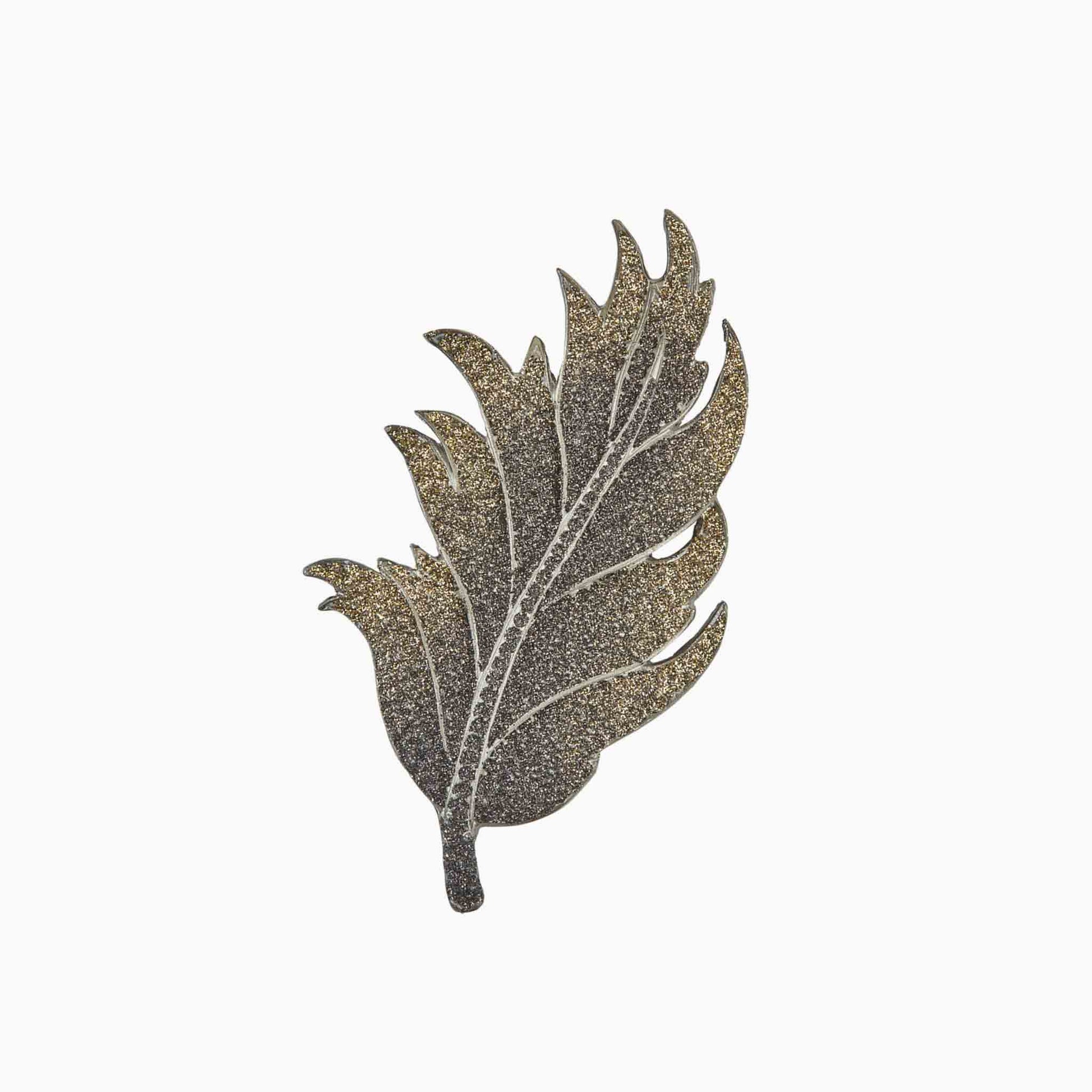 Decorative leaf-shaped brooch on a white background
