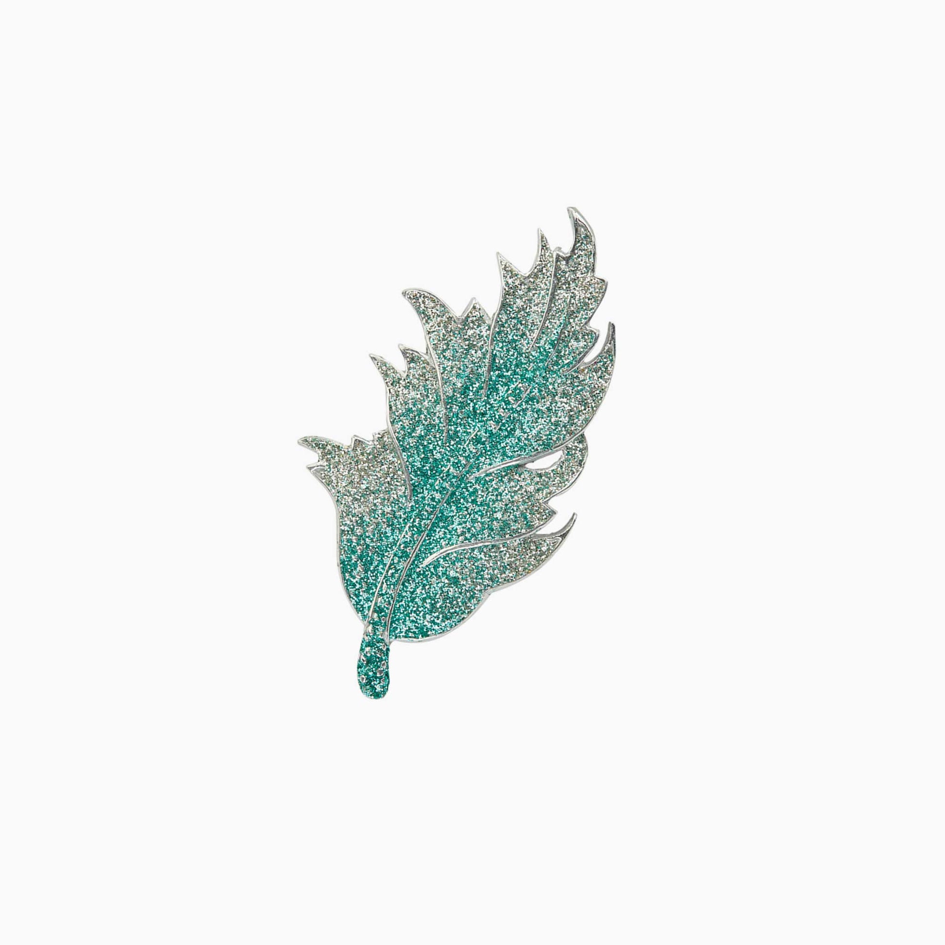 Decorative leaf-shaped brooch on a white background