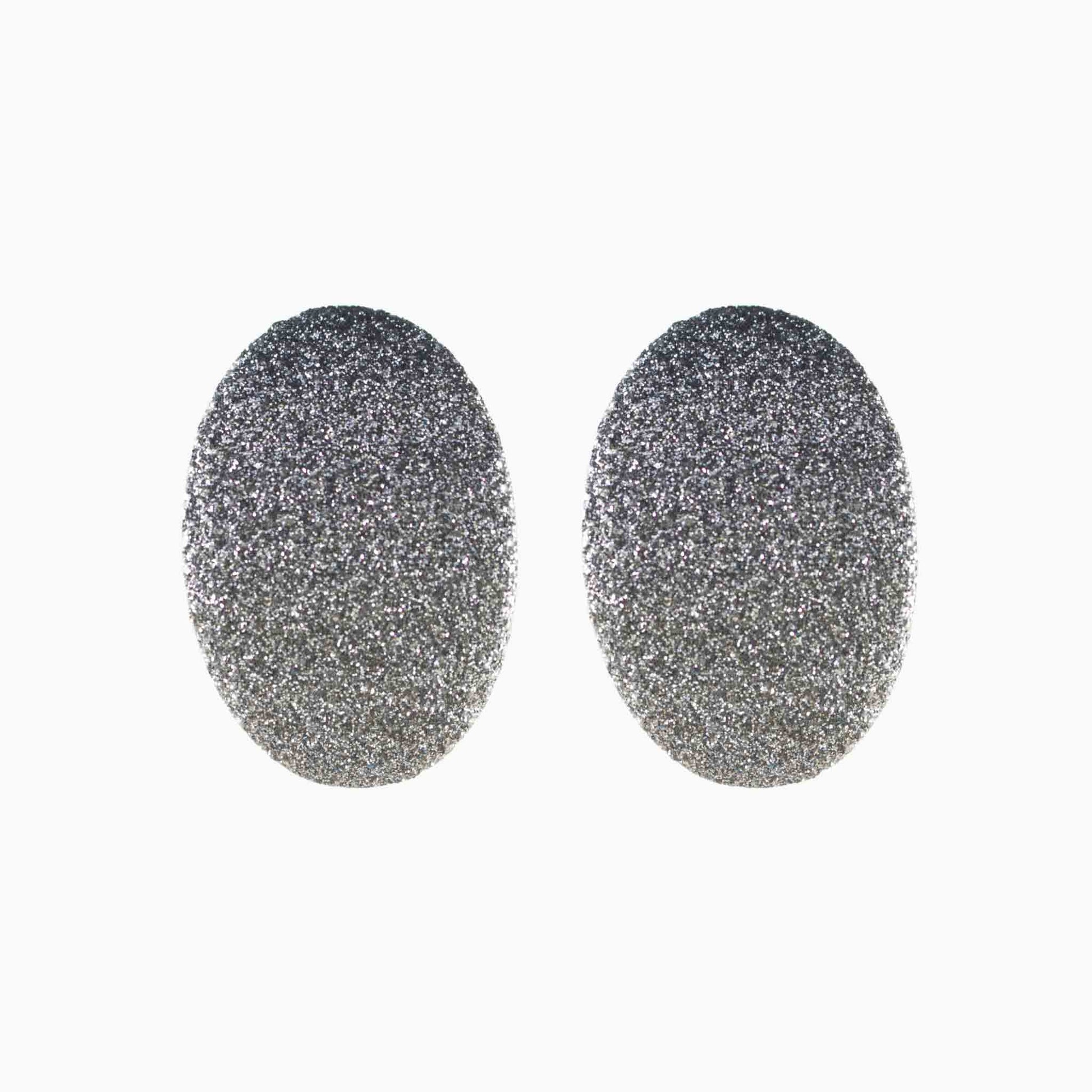 Pair of silver glittery oval earrings on a white background