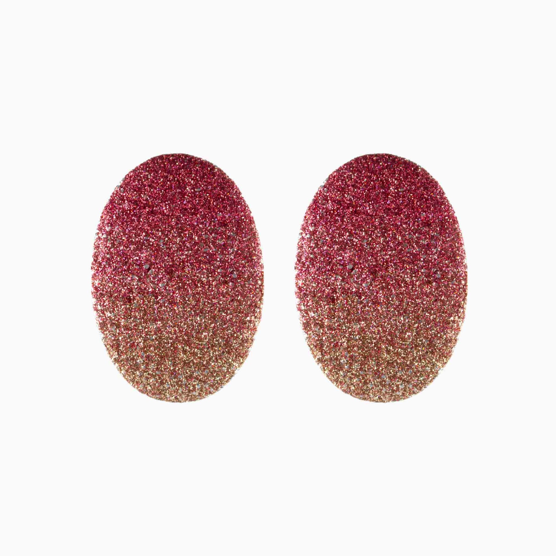 Pair of glittery pink and gold earrings on a white background