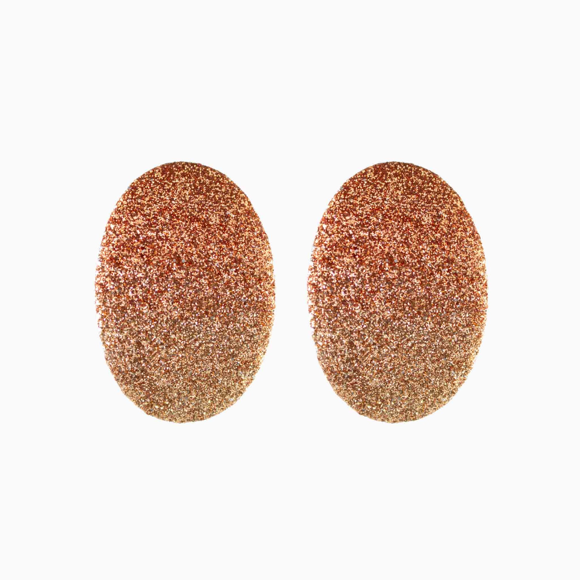 Pair of rose gold glittery oval earrings on a white background