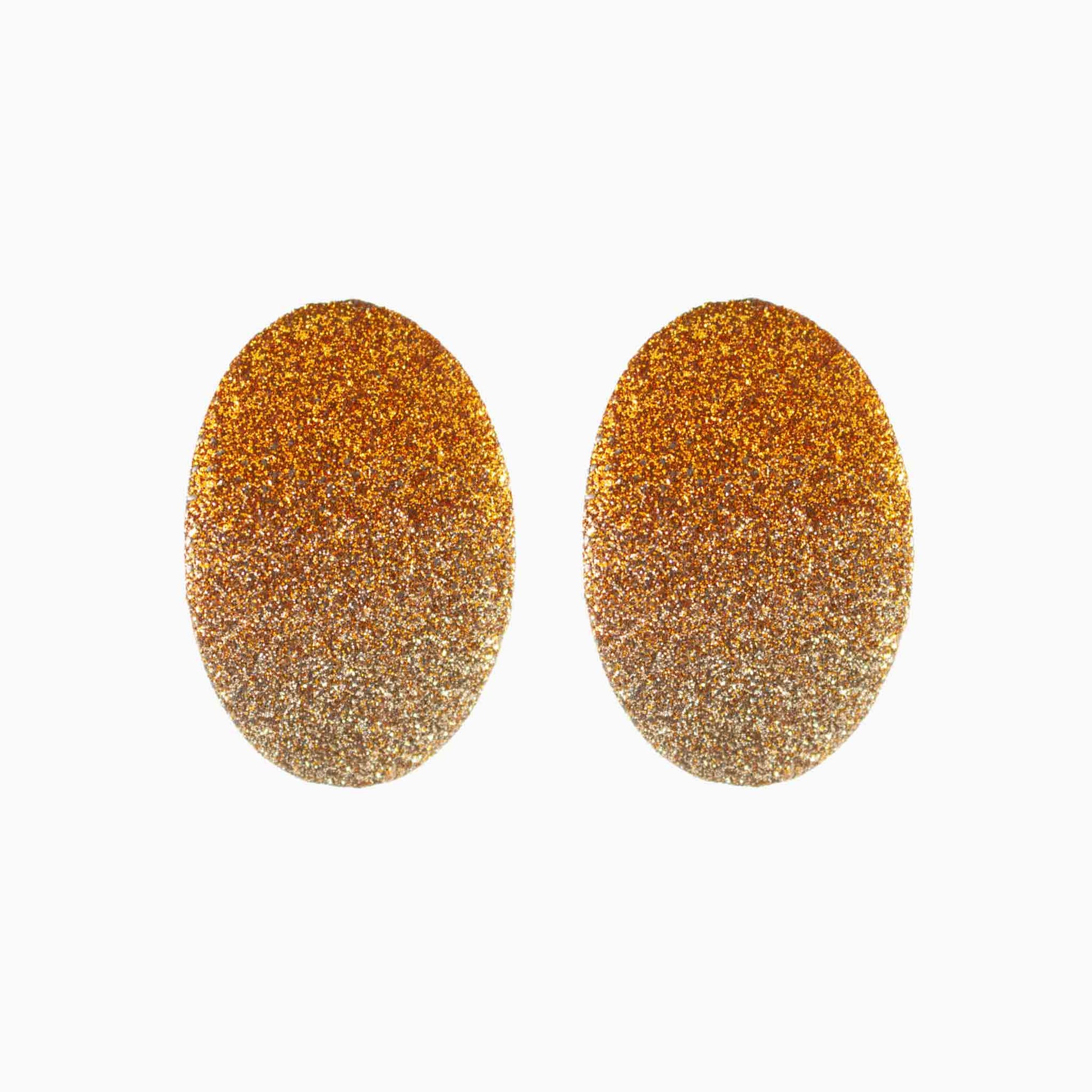 Pair of gold glittery oval earrings on a white background