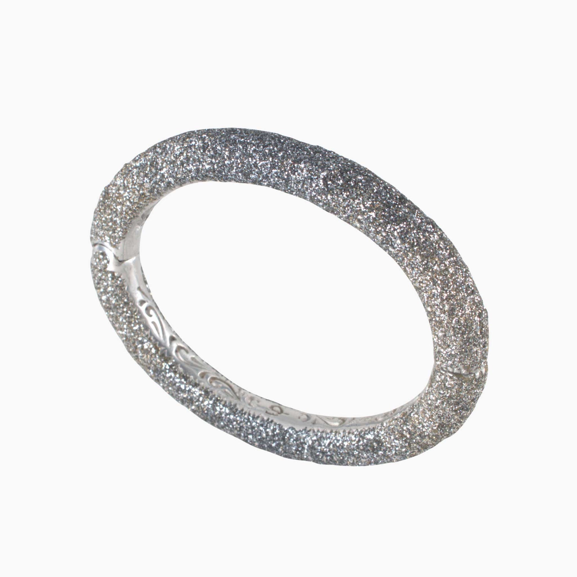 Silver bracelet with glittery texture on a white background