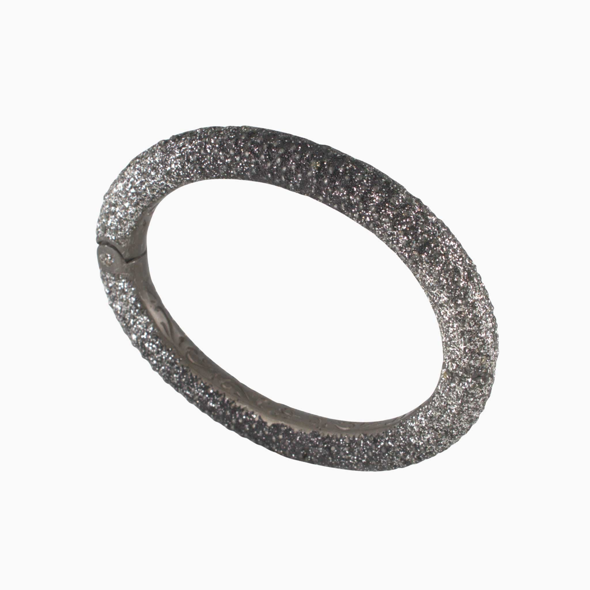 Silver bracelet with a textured band on a white background